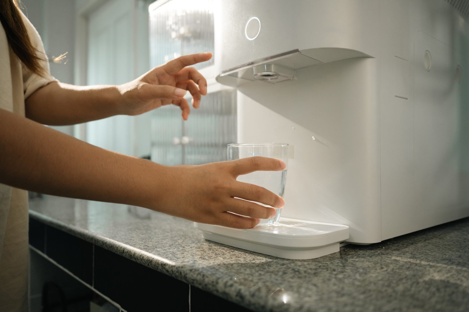 woman-using-water-purifier-marble-countertop-in-a-2025-07-01-01-19-04-utc (1)